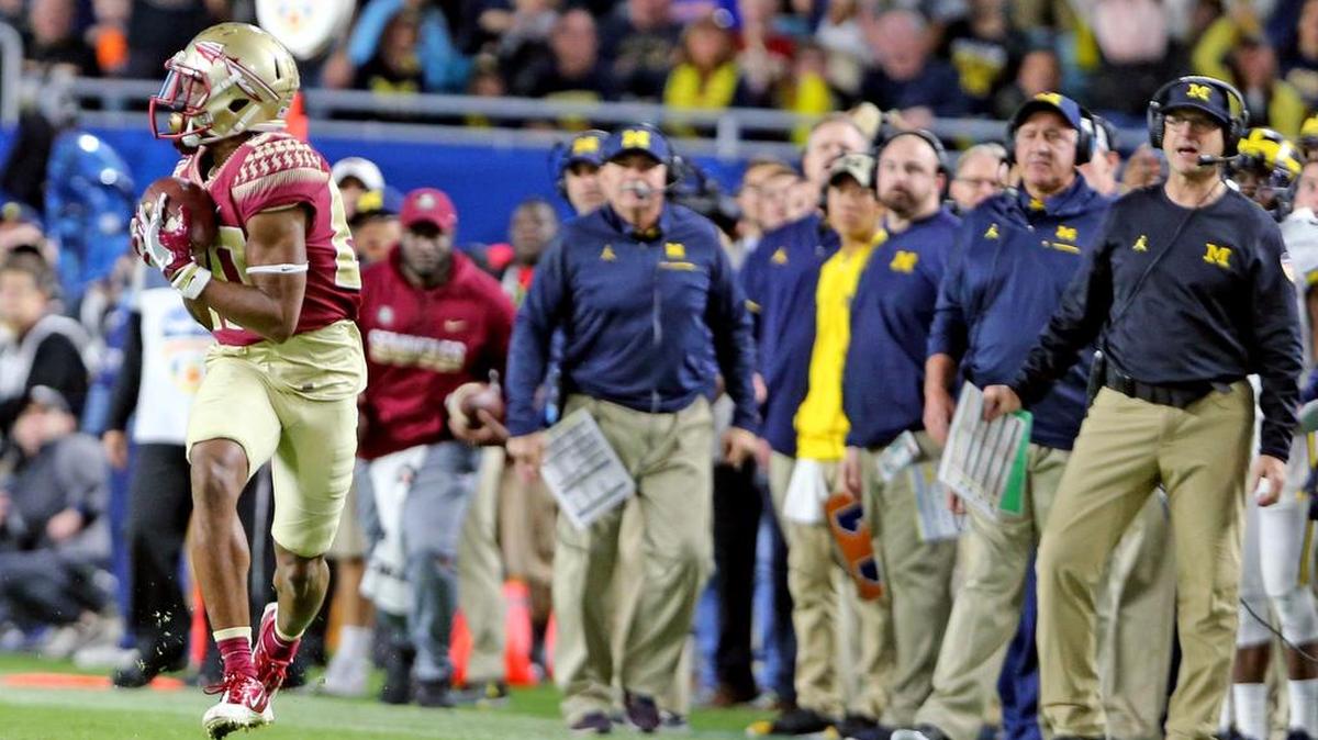 Michigan Wolverines coach Jim Harbaugh (far right) watches as Florida State Seminoles Nyqwan Murray catches a ball and runs for a touchdown in the first quarter in the 2016 Capital One Orange Bowl at Hard Rock Stadium in Miami Gardens Friday, Dec. 30, 2016.