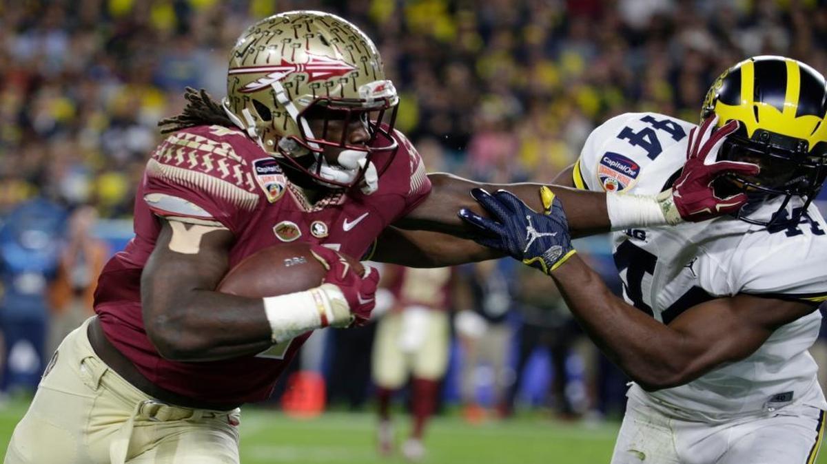 Michigan safety Delano Hill, right, attempting to stop Florida State running back Dalvin Cook, left, during the first half of the Orange Bowl NCAA college football game in Miami Gardens, Fla.