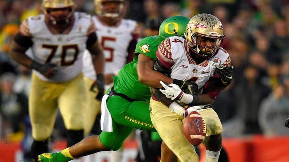 
Oregon linebacker Justin Hollins, front left, forces a fumble by Florida State running back Dalvin Cook during the second half of the Rose Bowl NCAA college football playoff semifinal, Thursday, Jan. 1, 2015, in Pasadena, Calif.
