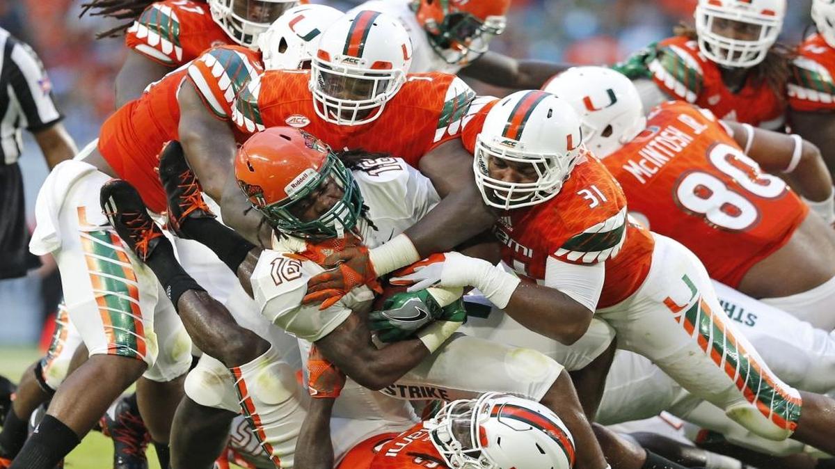 The Hurricane defense gang tackles FAMU running back Hans Supre in the first quarter as the University of Miami hosts Florida A&M at Hard Rock Stadium on Sat., Sept. 3, 2016.