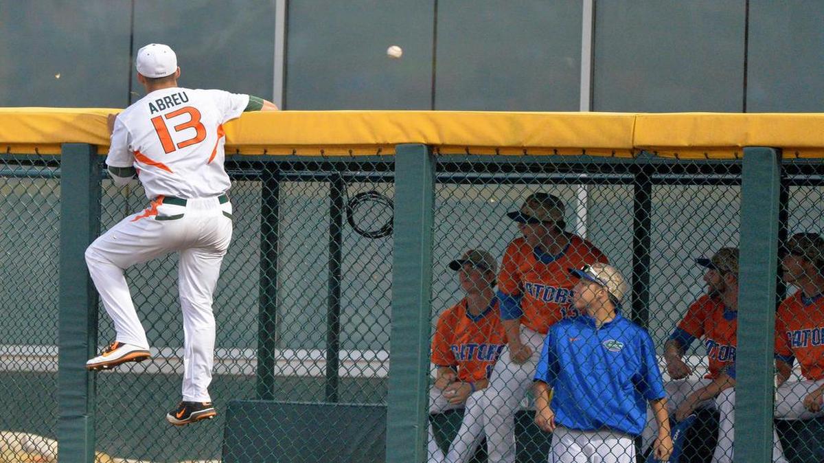 
Miami Hurricanes right fielder Willie Abreu climbs the bullpen fence but can’t prevent a home run by Florida's Richie Martin in the sixth inning Wednesday night. 

