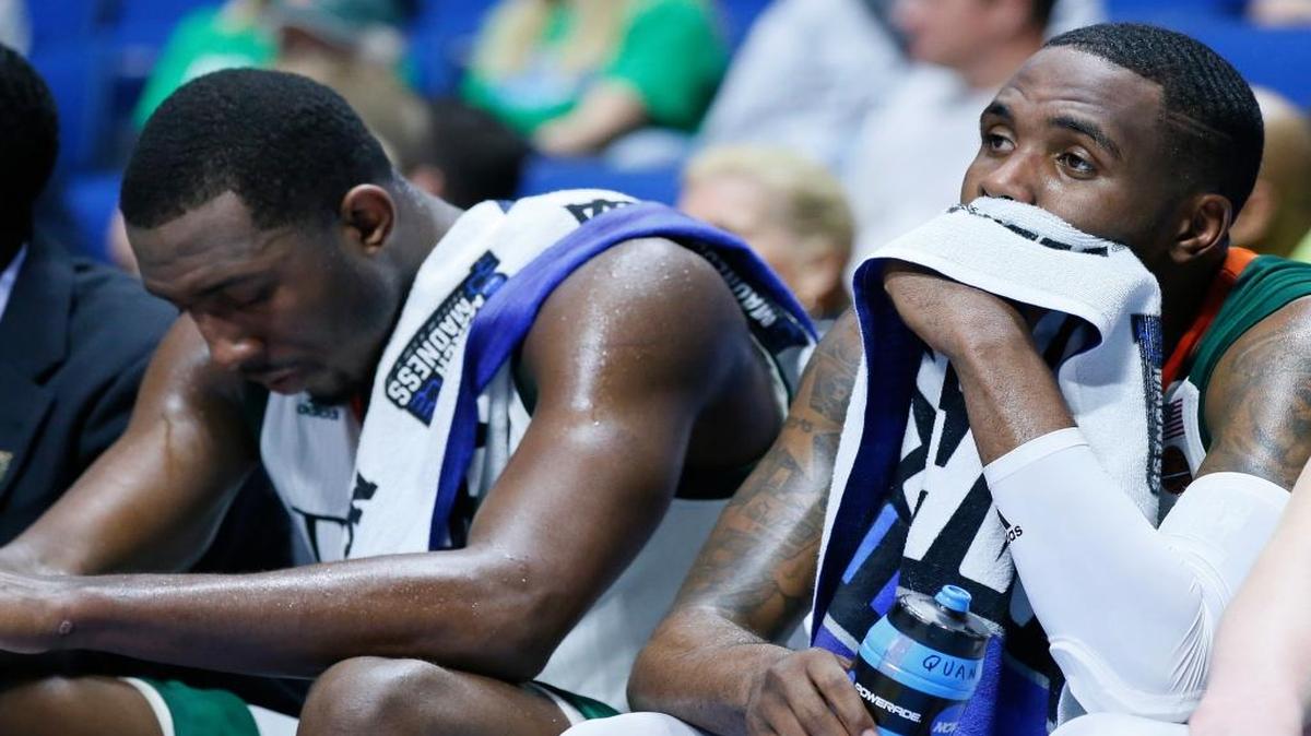 Miami’s Ja’Quan Newton, right, and Davon Reed sit on the bench late in the second half of the Hurricanes’ first-round loss to Michigan State in the NCAA Tournament on Friday night in Tulsa, Oklahoma.