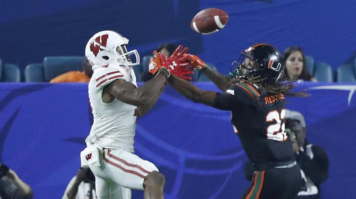 Wisconsin Badgers wide receiver A.J. Taylor (4) scores on a pass reception in the end zone as Miami Hurricanes defensive back Sheldrick Redwine (22) defends in the second quarter on Saturday.