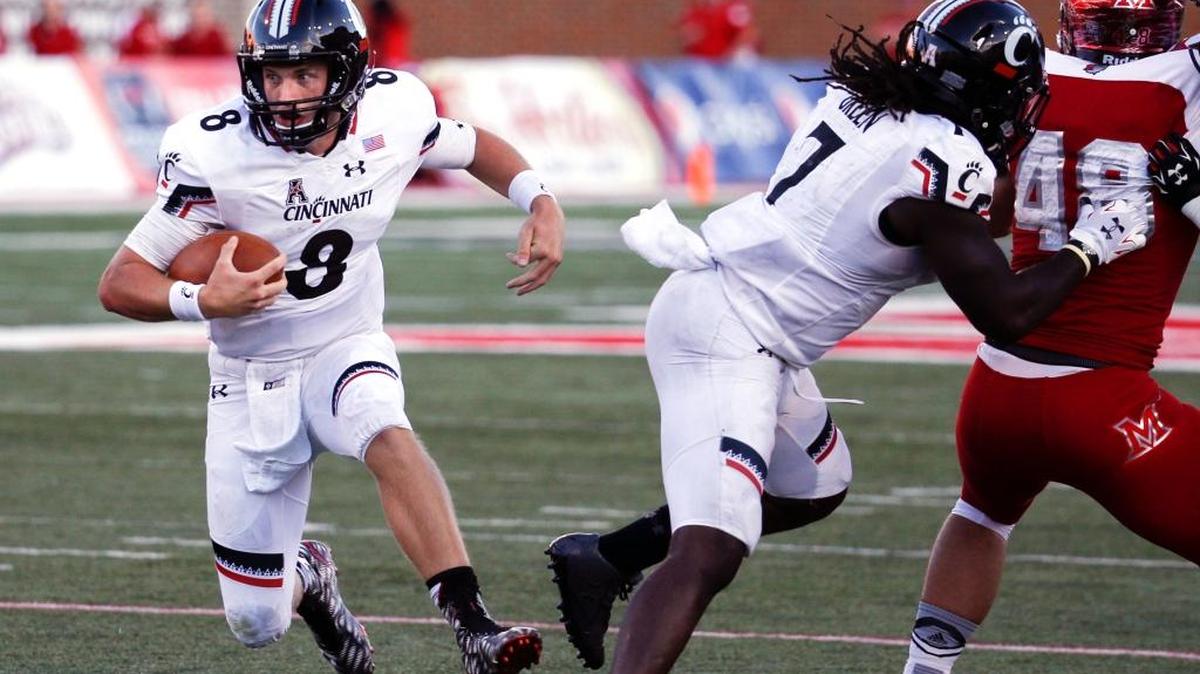 
Cincinnati quarterback Hayden Moore, left, runs the ball in the second half against Miami of Ohio at Yager Stadium, Saturday, Sept. 19, 2015, in Oxford, Ohio. Cincinnati won 37-33. 
