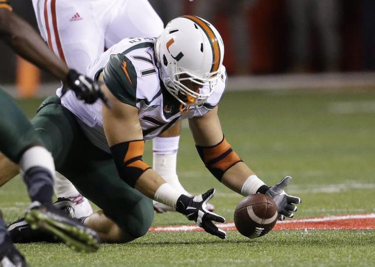 Miami defensive lineman Anthony Chickillo (71) recovers a fumble by Nebraska quarterback Tommy Armstrong Jr. in the first half of an NCAA college football game in Lincoln, Neb., Saturday, Sept. 20, 2014.