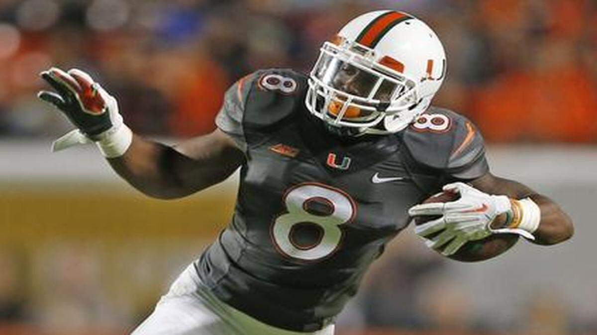 
Miami Hurricanes running back Duke Johnson (8) is tripped up by Pittsburgh Panthers defensive back Avonte Maddox (14) as the University of Miami hosts Pittsburgh at Sun Life Stadium in Miami Gardens on Nov. 29, 2014.

