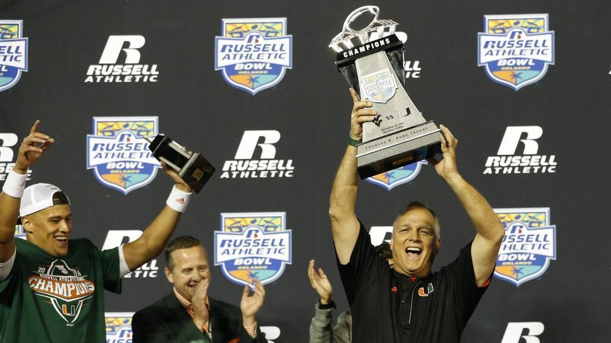 Miami Hurricanes head coach Mark Richt raises the championship trophy after the University of Miami defeats West Virginia at the Russell Athletic Bowl in Orlando on Wednesday, December 28, 2016.