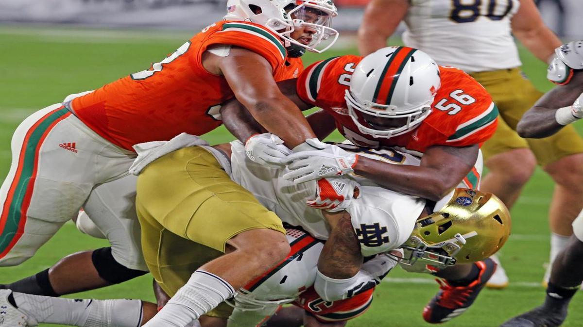 Miami Hurricanes Trent Harris (33) and Michael Pinckney (56) tackle Notre Dame's Josh Adams (33)on Saturday, Nov. 11, 2017 at Hard Rock Stadium in Miami Gardens, Fla. (Charles Trainor Jr./Miami Herald/TNS). The Hurricanes face Virginia at home on Saturday.