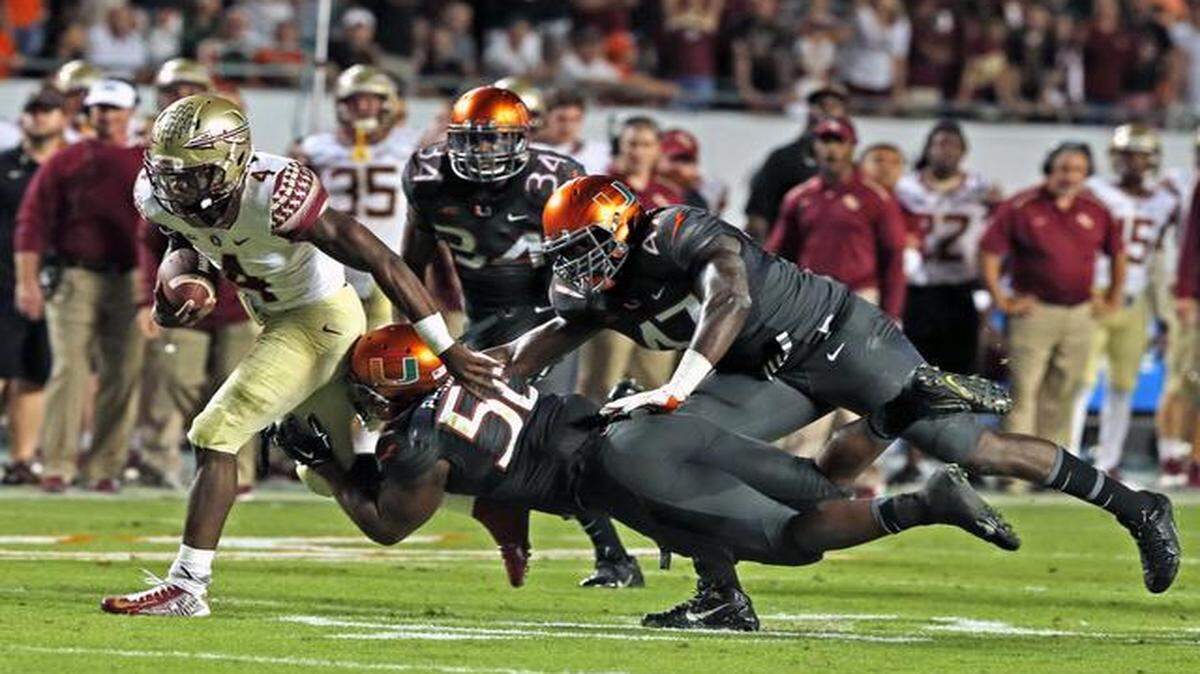 
Busting loose: FSU running back Dalvin Cook (Miami Central) breaks through the Hurricanes defense for 26 yards and the winning touchdown in the fourth quarter of Saturday night’s game at Sun Life Stadium. The win kept the defending national champions in the college football playoff hunt.
