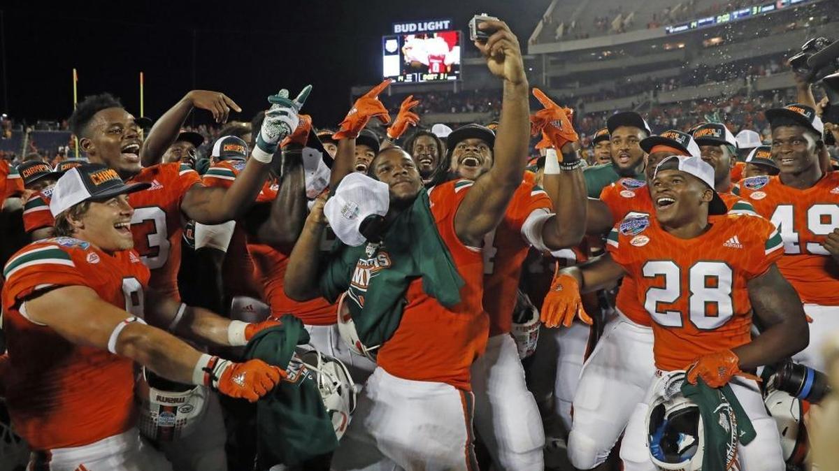 Miami Hurricanes running back Mark Walton celebrates with his teammates after Miami’s win over West Virginia in Orlando on December 28.