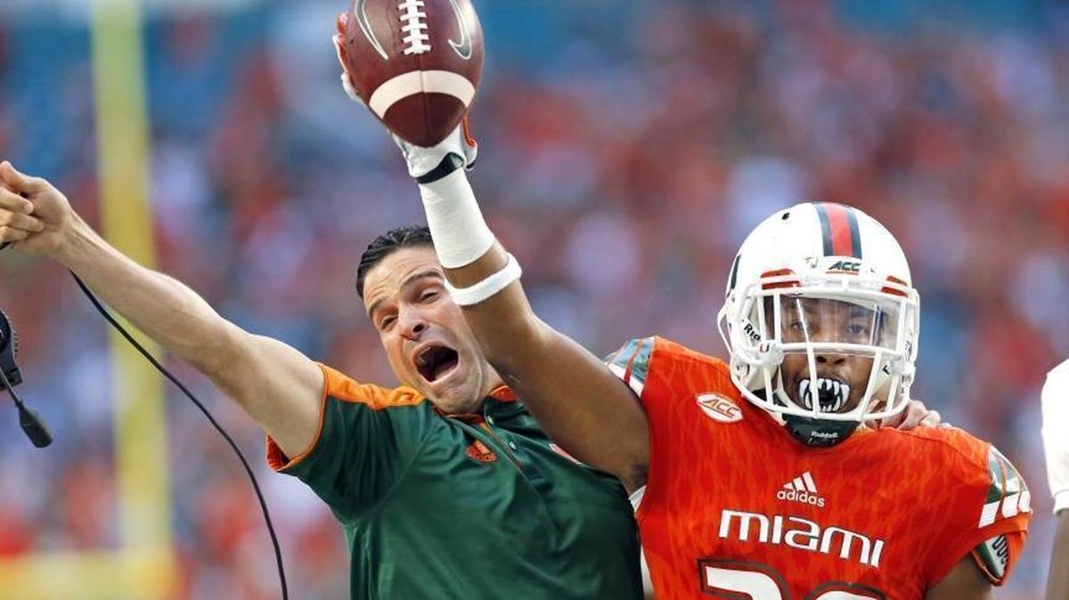 Manny Diaz celebrates last year with former UM cornerback Corn Elder after Elder makes an interception at Hard Rock Stadium. Diaz has been nominated for the 2017 Broyles Award that goes to the top assistant coach in college football.