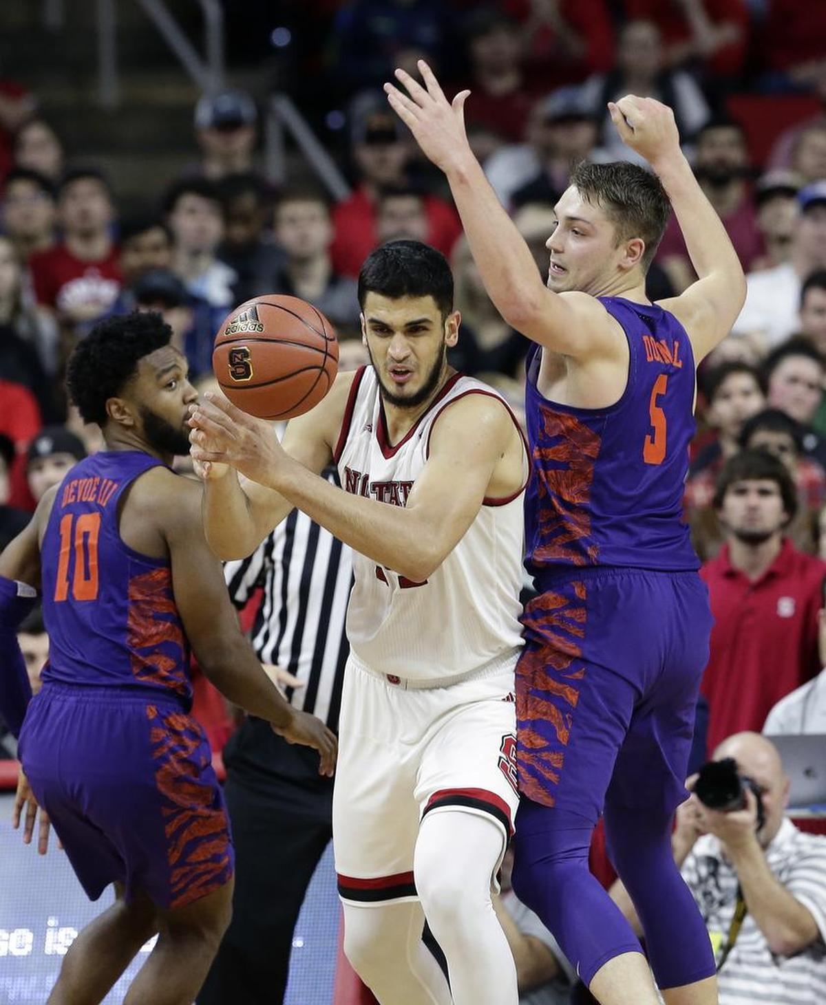 Clemson’s Gabe DeVoe (10) and Mark Donnal (5) guard North Carolina State’s Omer Yurtseven on Jan. 11.