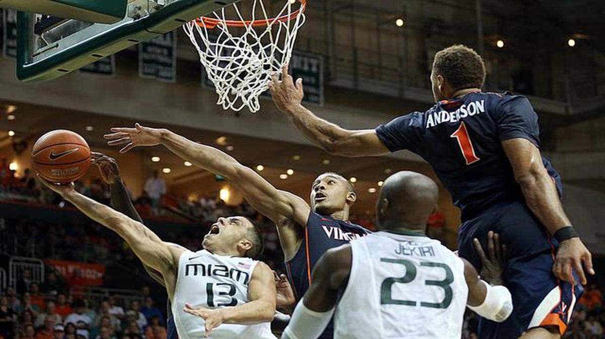 
The Hurricanes’ Angel Rodriguez attempts a layup against Virginia's Darion Atkins, center, and Justin Anderson in the second half.


