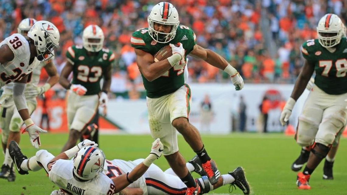 Miami Hurricanes running back Travis Homer (24) breaks a tackle for a touchdown in the fourth quarter of the Hurricanes’ win against Virginia Saturday.
