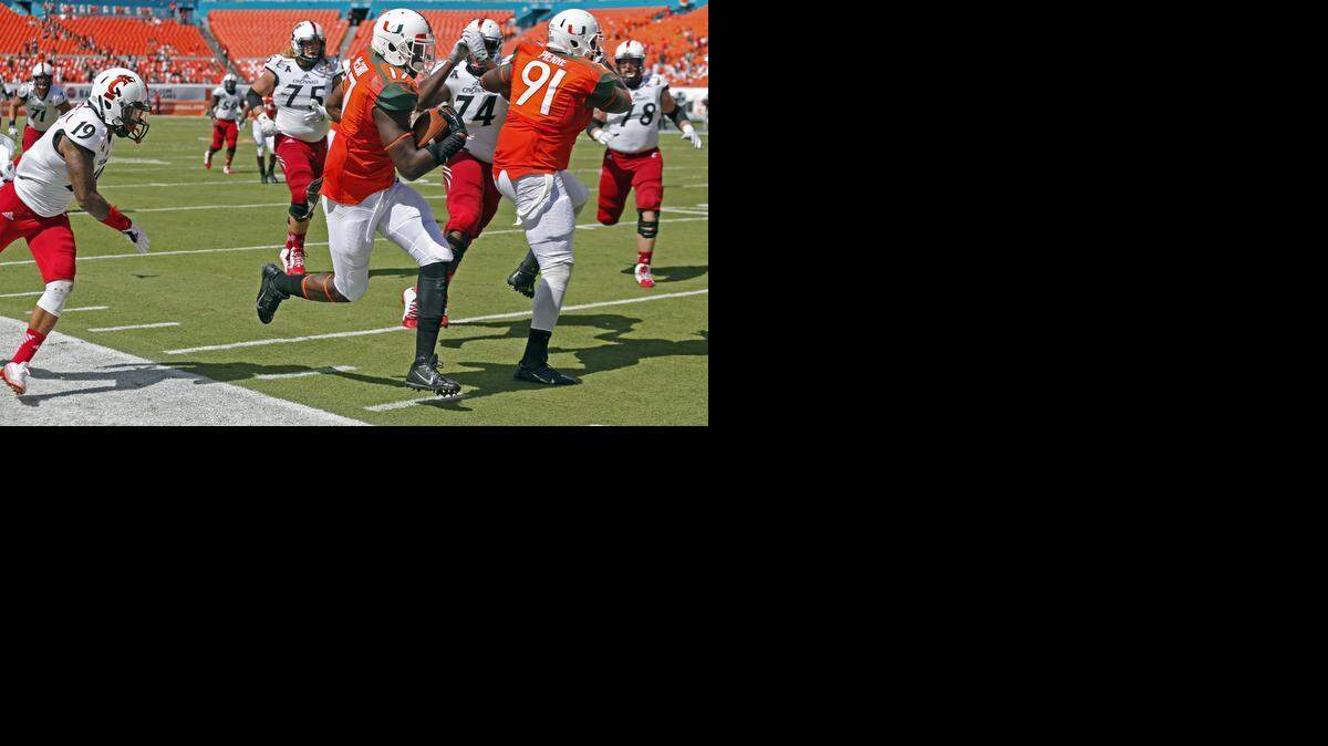 
Miami Hurricanes linebacker Tyriq McCord (17) in his way to score after intercepting the ball at the start of the third quarter as the University of Miami hosts Cincinnati at Sun Life Stadium on Saturday, October 11, 2014.
