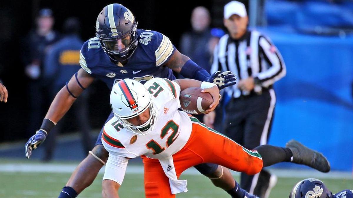 Miami Hurricanes quarterback Malik Rosier (12) falls to the field as Pitt’s James Folston Jr. (40) falls on him during the third quarter at Heinz Field in Pittsburgh on Friday, Nov. 24, 2017.