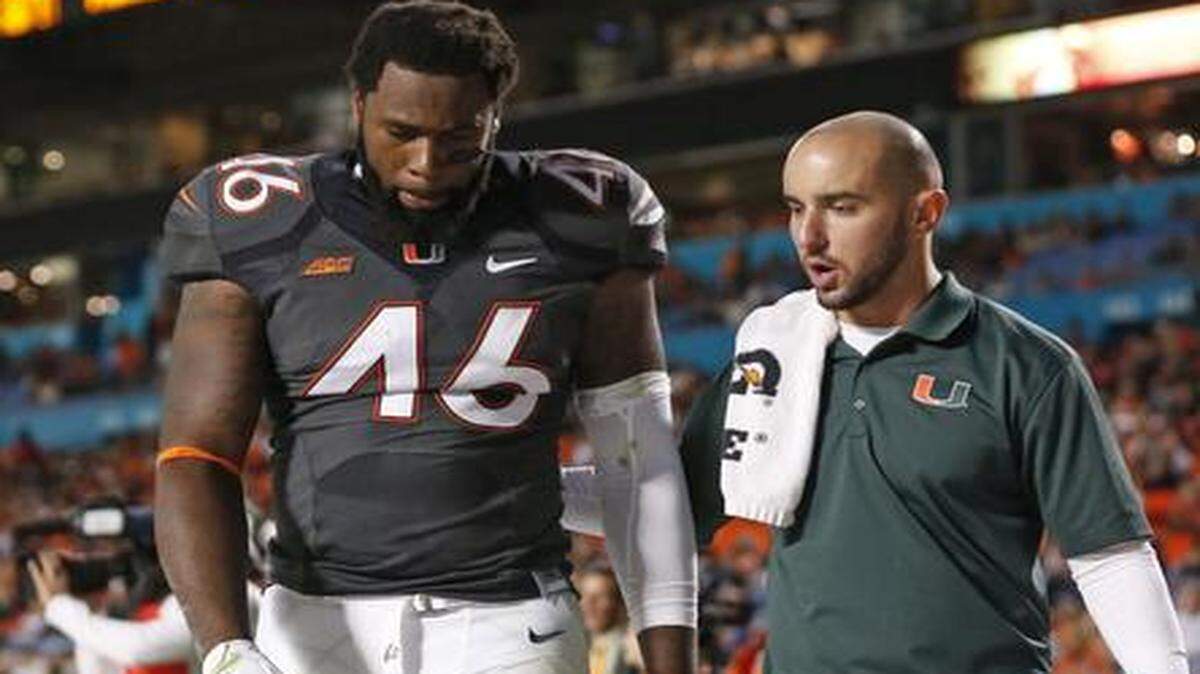
Miami Hurricanes tight end Clive Walford (46) is assisted off the field after breaking school record in the second quarter of UM's game against Pittsburgh at Sun Life Stadium on Saturday, Nov. 29, 2014.
