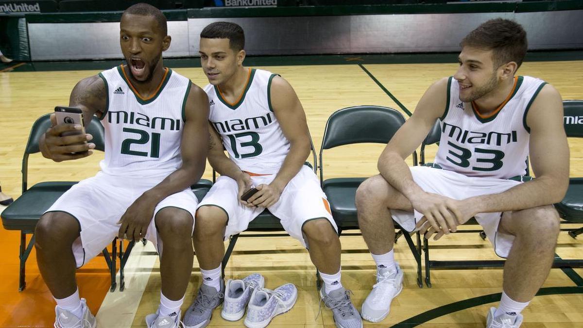 Kamari Murphy (21) and guard Angel Rodriguez (13) pose for their own photo as forward Ivan Cruz Uceda (33) looks on, while they wait to take a team photo during Miami's media day in Coral Gables, Fla.