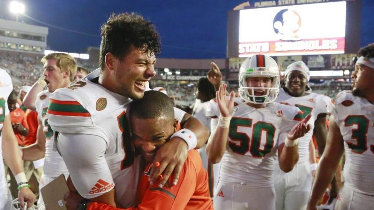 Miami Hurricanes quarterback Malik Rosier gets a hug by graduate assistant Tyler Pearson after UM defeats the Seminoles at Doak Campbell Stadium in Tallahassee on Saturday, October 7, 2017.