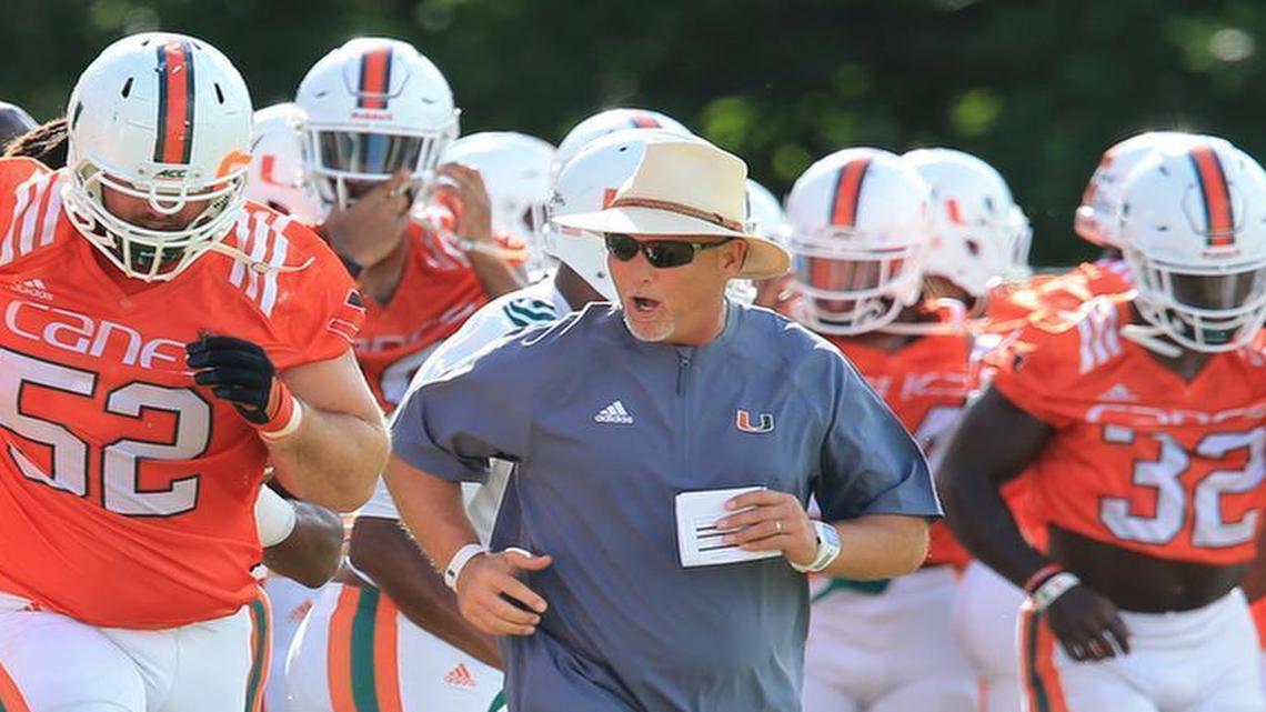 Mark Richt, with left tackle Kc McDermott (52) by his side, runs out to drills during football practice at the University of Miami on Wednesday, August 23, 2017.