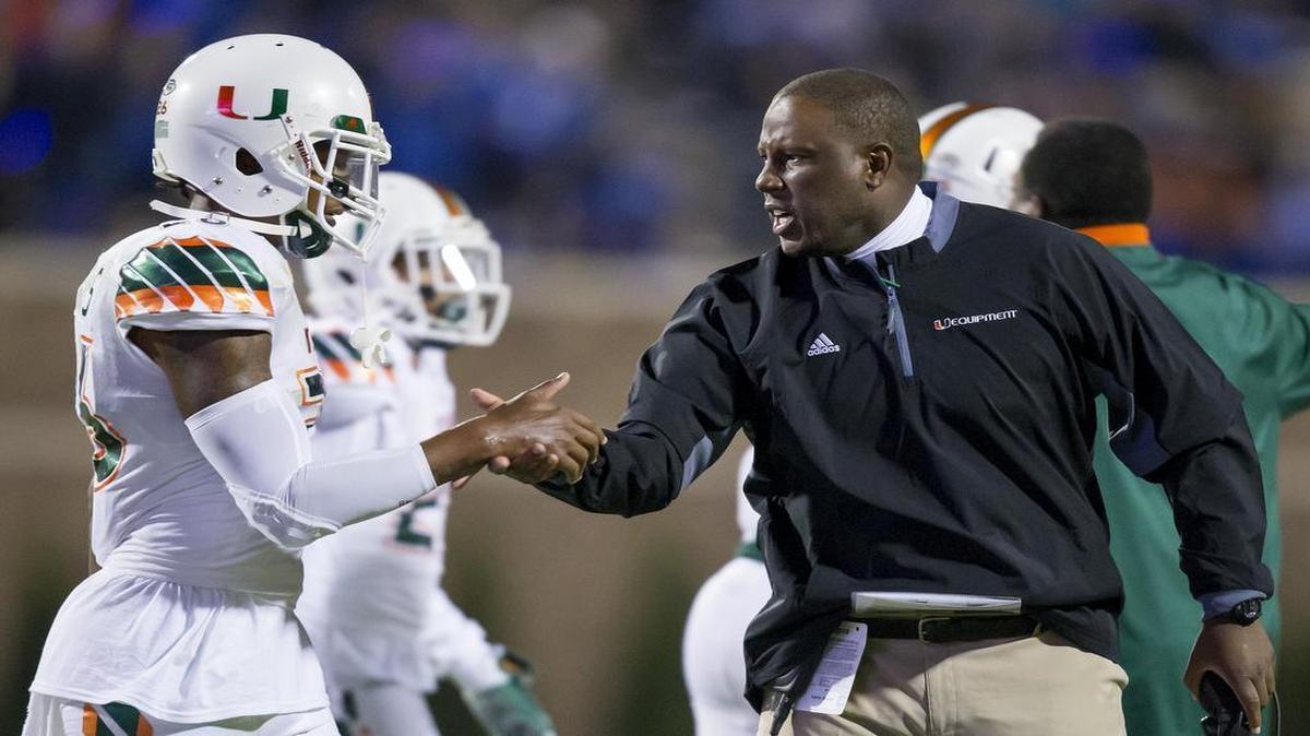 Miami interim head coach Larry Scott congratulates Rayshawn Jenkins after a defensive stop during the second half of an NCAA college football game, in Durham, N.C., Saturday, Oct. 31, 2015.