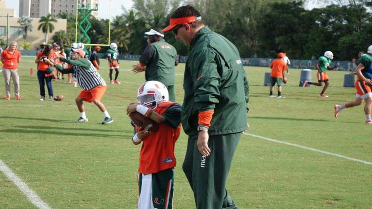 
Future Hurricane: UM coach Al Golden shows Carter Hucks around the team’s practice facility. The Make-A-Wish Foundation arranged for Hucks to visit the campus.

