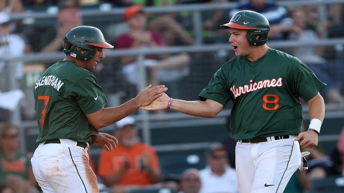 
University of Miami's George Iskenderian and David Thompson celebrate as they cross home plate as UM plays Columbia and hosts the Coral Gables Regional final on Monday, June 1, 2015
