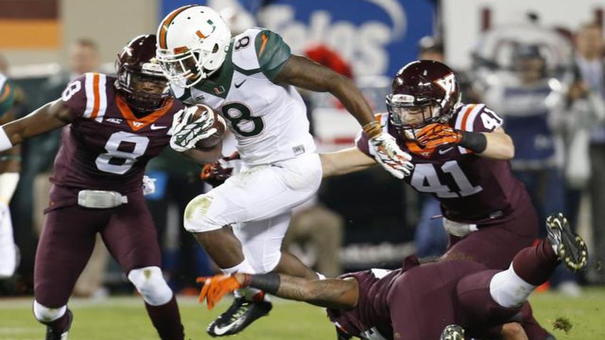 
Miami running back Duke Johnson (8) breaks a tackle by Virginia Tech linebacker Andrew Motuapuaka, bottom right, as linebacker Derek Di Nardo (41) and safety Detrick Bonner (8) defend during the first half of an NCAA college football game in Blacksburg, Va., Thursday, Oct. 23, 2014.

