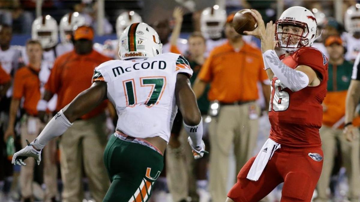 
FAU quarterback Jason Driskel prepares to pass under pressure from Miami linebacker Tyriq McCord on Friday, Sept. 11, 2015, in Boca Raton, Fla. 

