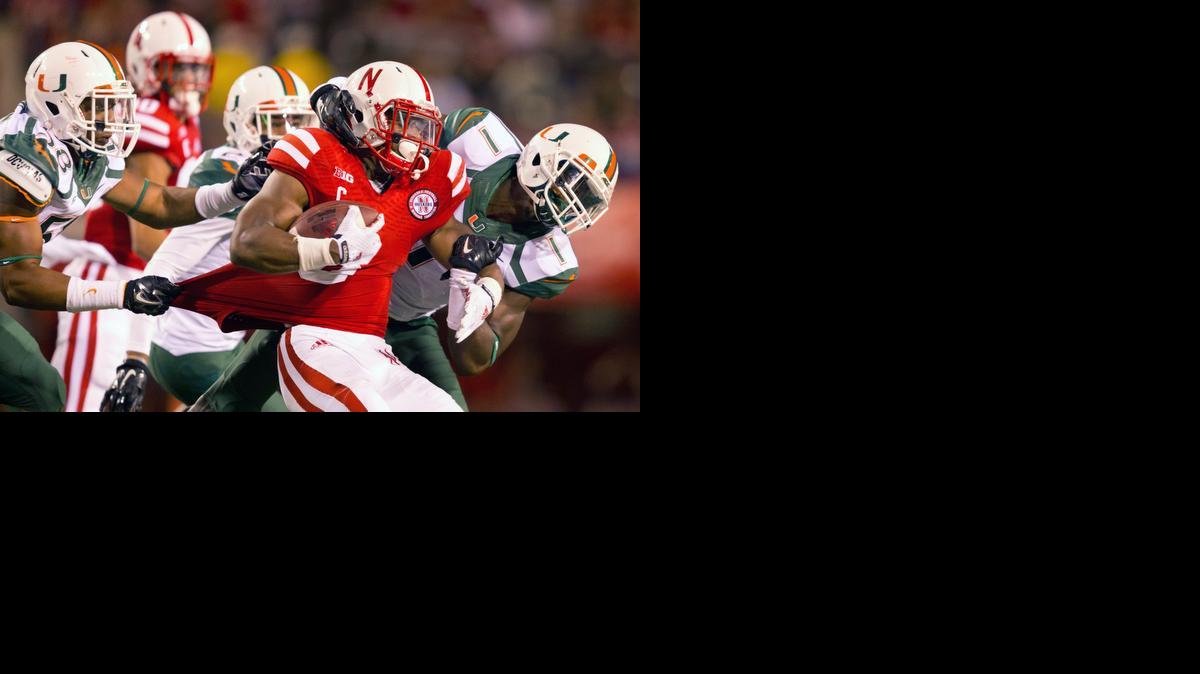 
Nebraska running back Ameer Abdullah (8) is brought down by a host of Hurricane defenders in the first half of an NCAA college football game in Lincoln, Neb., Saturday, Sept. 20, 2014. 
