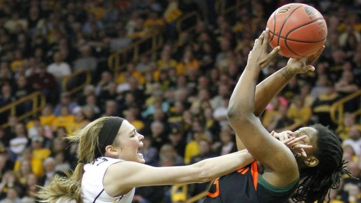 
In your face: Iowa guard Ally Disterhoft, left, fights for the ball with Miami forward Necole Sterling.
