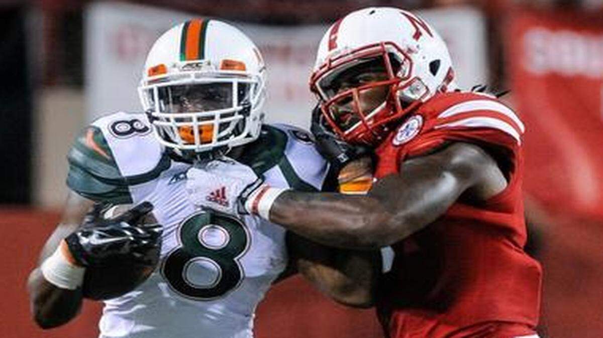 
Wrapped up: Nebraska safety Corey Cooper tackles UM running back Duke Johnson during the first half 
of the Cornhuskers’ victory Saturday. Johnson rushed for 93 yards and a touchdown for the Hurricanes.

