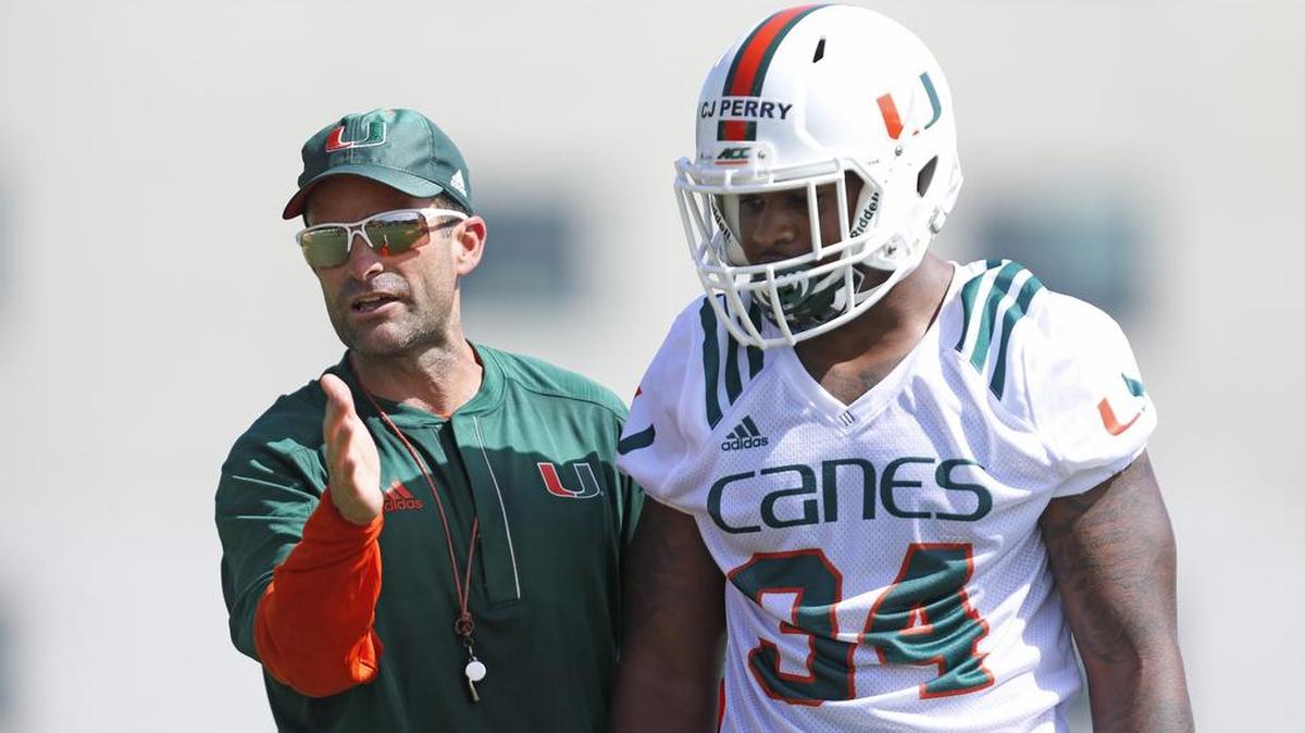 Miami defensive coordinator Manny Diaz coaches Miami Hurricanes linebacker Charles Perry (34) during opening day of Miami Hurricanes football practice in Coral Gables on Thurs., Aug. 4, 2016.