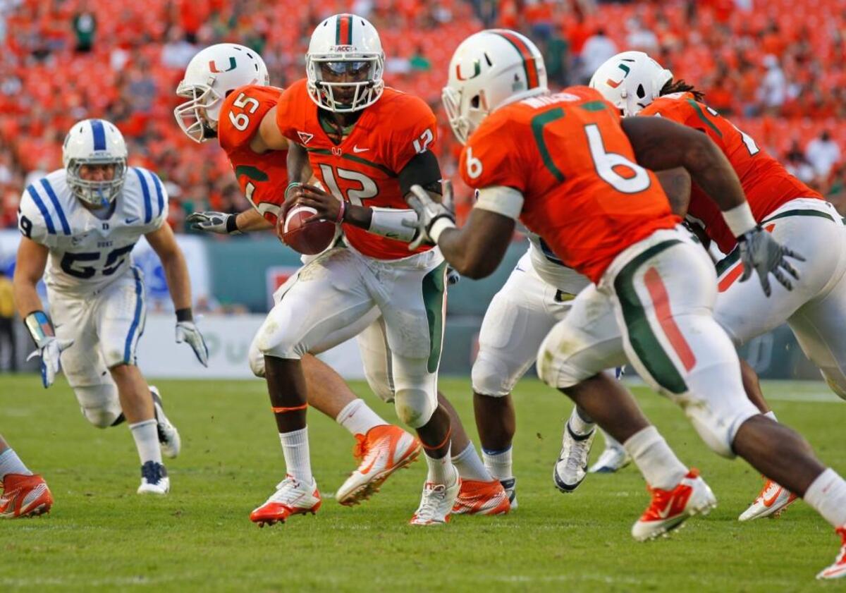 Miami's Jacory Harris hands off to Lamar Miller in the third quarter against Duke in 2011.