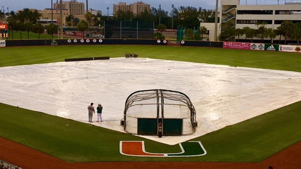 Virginia Tech coach Patrick Mason, left, speaks with Miami Hurricanes coach Jim Morris while they wait for the rain to end prior to Thursday night’s game at Mark Light Field. The game was postponed and will be made up as part of a doubleheader Friday.