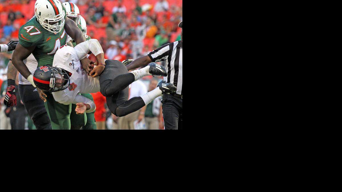 
University of Miami's Ufomba Kamalu throws Arkansas State's quarterback Fredi Knighten to the ground in the third quarter at Sun Life Stadium in Miami Gardens on Sept. 13, 2014.
