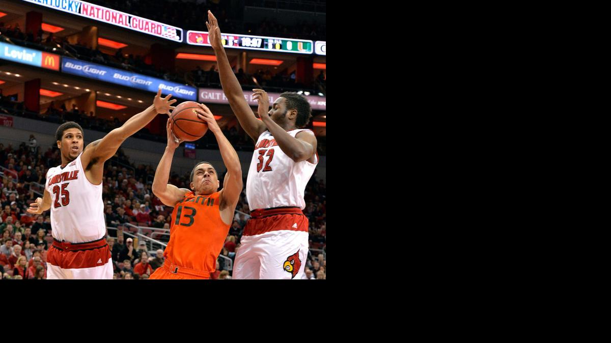 
Miami Hurricanes point guard Angel Rodriguez, center, attempts a shot between the defense of Louisville's Wayne Blackshear, left, and Chinanu Onuaku during the first half of an NCAA college basketball game in Louisville, Ky. on Feb. 21, 2015.
