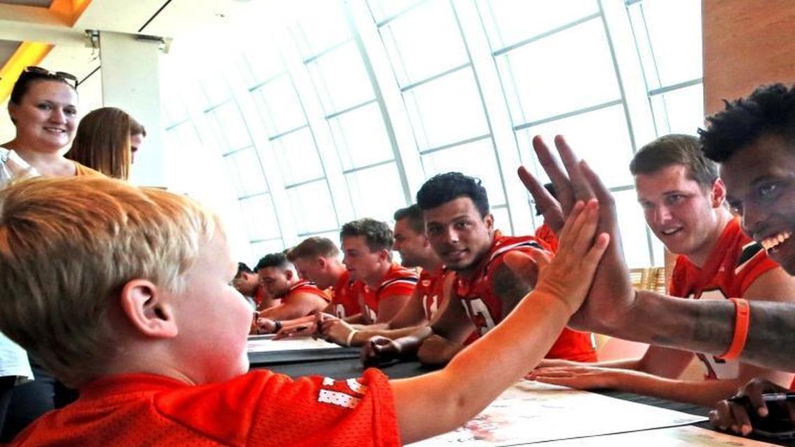 Miami Hurricanes' freshman quarterback N'Kosi Perry (5) slaps five with Reed Ruttkay 4, as players sign autographs at CanesFest after the team's scrimmage at Hard Rock Stadium, August 12, 2017.
