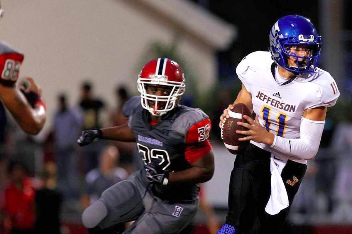 Tampa Jefferson quarterback Cade Weldon looks for an open receiver while Hillsborough linebacker Armand Chalk (32) purses him during the first quarter of their game on Sept. 5, 2014 at Hillsborough High School.