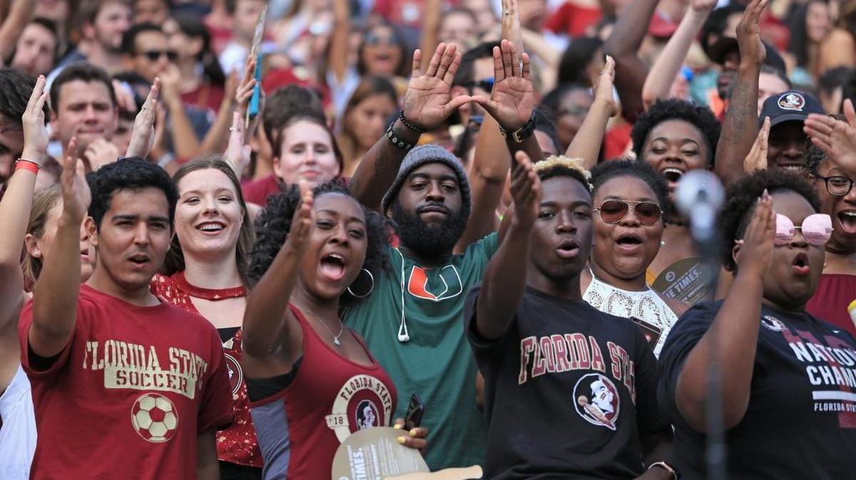 A UM fan flashes the ‘U’ while surrounded by FSU fans doing the tomahawk chop as the Seminoles host the Miami Hurricanes at Doak Campbell Stadium in Tallahassee on Saturday, October 7, 2017.