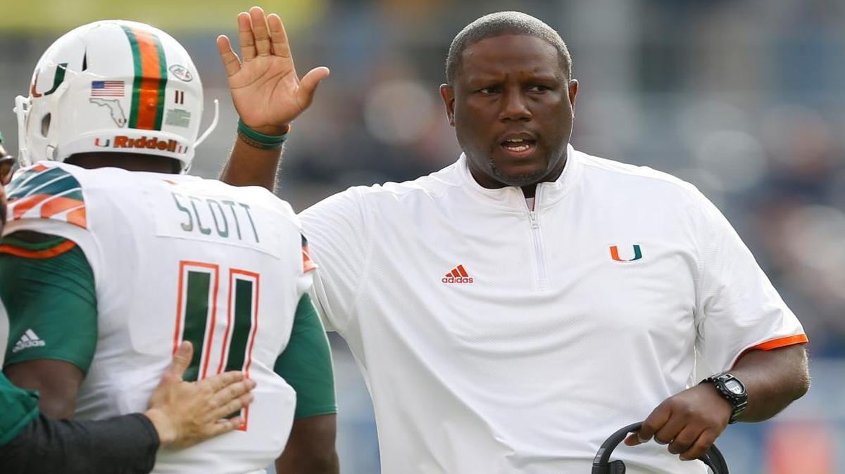 UM interim head coach Larry Scott congratulates wide receiver Rashawn Scott (11) after the team scored a touchdown in the first quarter against Pittsburgh, Friday, Nov. 27, 2015, in Pittsburgh. Miami won 29-24.