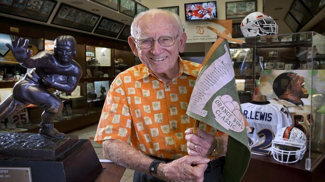
G. Holmes Braddock holds a pennant from the 1950 Orange Bowl Classic. Braddock was a graduate student at the University of Miami at the time. Braddock watched his first Hurricanes football game as a 21-year-old University of Miami freshman - in 1946. He has missed 12 home games out the last 431 home games in 69 seasons. He's back for more in 2015 as he visits the University of Miami Sports Hall of Fame on Tuesday, August 18, 2015.
