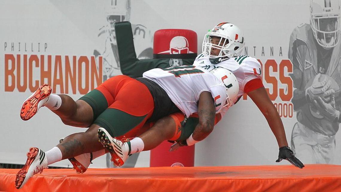 Gerald Willis, left, tackles Trent Harris, right, during practice drills last August.