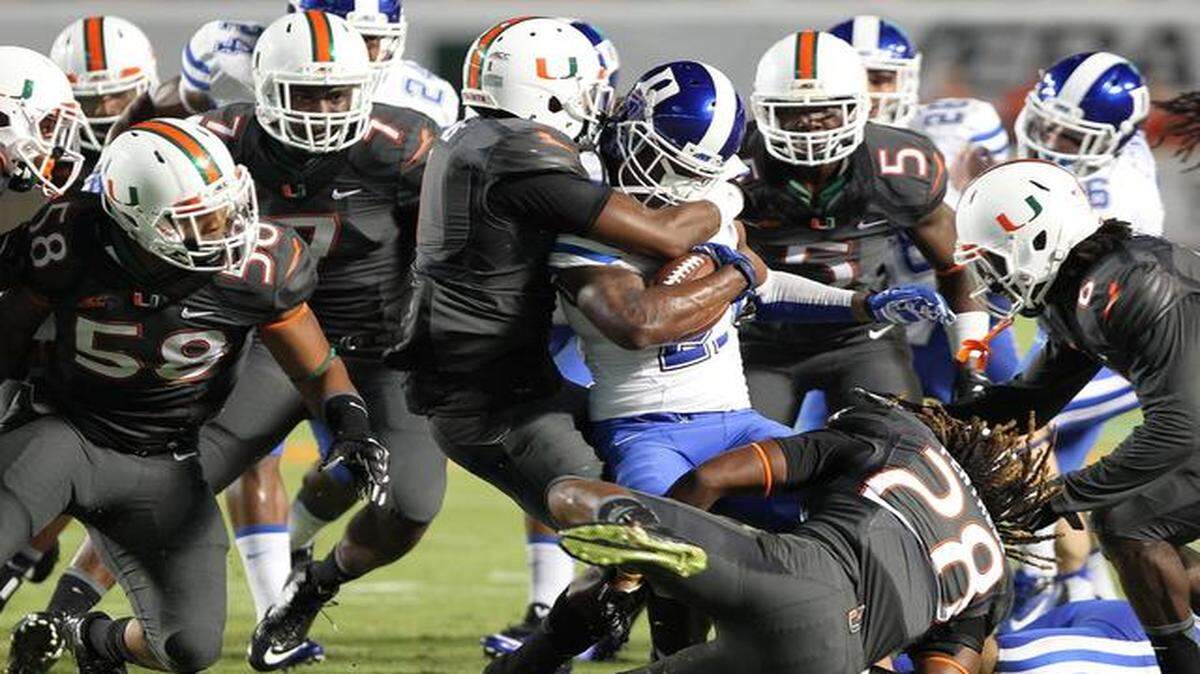 <cutline_leadin>Smothered: </cutline_leadin>UM defenders converge on and take down the Blue Devils’ DeVon Edwards in the third quarter of the Hurricanes’ victory in their Atlantic Coast Conference Coastal Division opener at Sun Life Stadium on Saturday night.