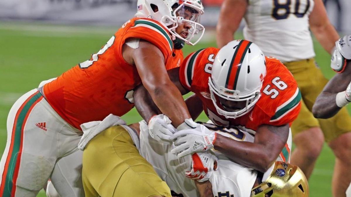 Miami Hurricanes Trent Harris (33) and Michael Pinckney (56) tackle Notre Dame’s Josh Adams at Hard Rock Stadium in Miami Gardens on Nov. 11, 2017. The Hurricanes, who finished 10-3, have a No. 13 final AP ranking — two places below Notre Dame, which also finished 10-3 but is ranked 11th in the final AP Poll.