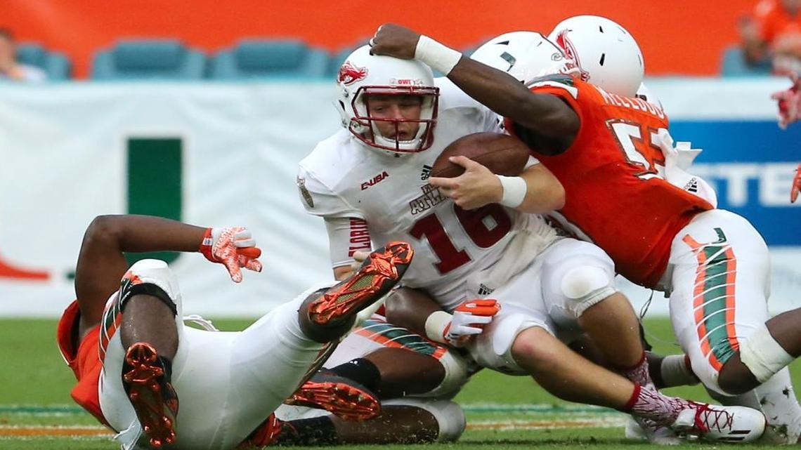 FAU Owls quarterback Jason Driskel is being sacked by University of Miami Hurricanes defensive linemen RJ McIntosh (80) and linebacker Zach McCloud (53) in the first quarter of an NCAA college football game, Sat., Sept. 10, 2016, in Miami.