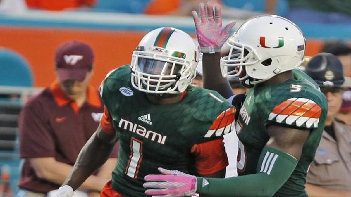 Miami Hurricanes defensive back Artie Burns (1) and linebacker Jermaine Grace (5) react after Burns’ interception in the fourth quarter against Virginia Tech at Sun Life Stadium on Saturday, October 17, 2015.