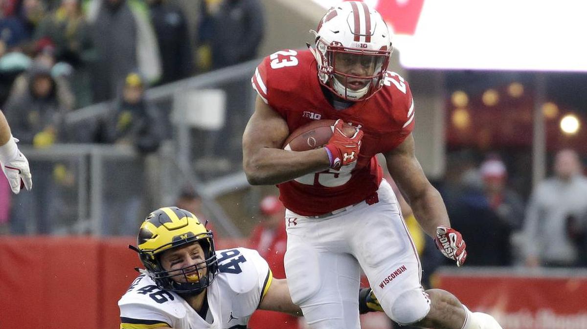 Wisconsin’s Jonathan Taylor runs past Michigan’s Chris Hanlon on Nov. 18, 2017, in Madison, Wisconsin. who Taylor leads the Big 10 with 1,847 rushing yards. He has scored 13 touchdowns and averages 6.8 yards per carry.