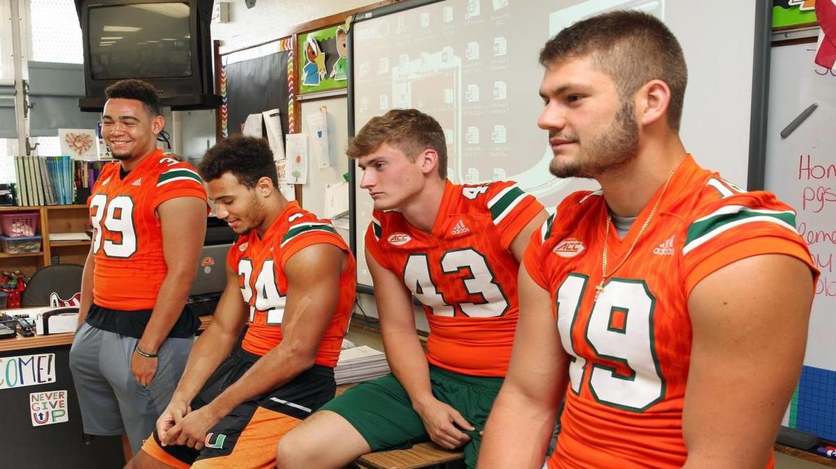 University of Miami players (left to right) Jordan Butler, Travis Homer, Jack Spicer and Scott Patchan talk with students from Francis S. Tucker Elementary School on Thursday, June 1, 2017, during a community service event.