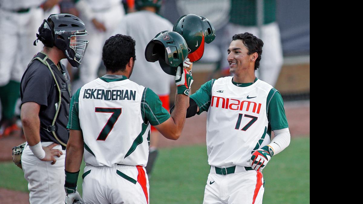 
Miami's Christopher Barr (17) is congratulated on his home run by teammate George Iskenderian (7) during the ninth inning of an Atlantic Coast Conference NCAA college baseball tournament game in Durham, N.C., Saturday, May 23, 2015. Miami won 6-5.
